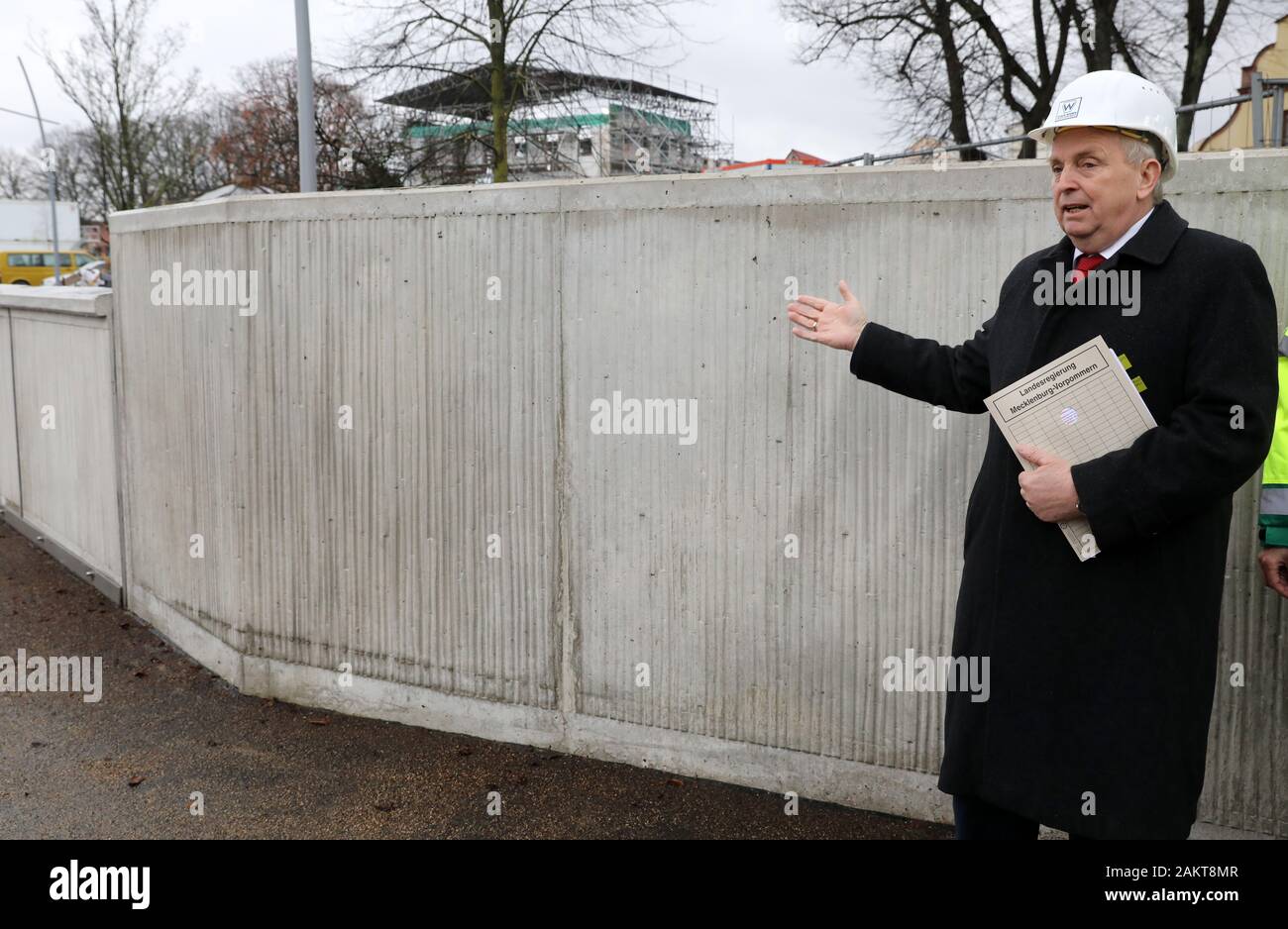 10 January 2020, Mecklenburg-Western Pomerania, Warnemünde: Till Backhaus (SPD), State Minister for the Environment, stands in front of the wall during the handover of the new storm surge protection wall on the southern Alter Strom. The structure, which is around 500 metres long, is 2.75 metres high and can therefore withstand water levels of up to 2.50. Due to the modular construction it is possible to raise the wall. Photo: Bernd Wüstneck/dpa-Zentralbild/dpa Stock Photo