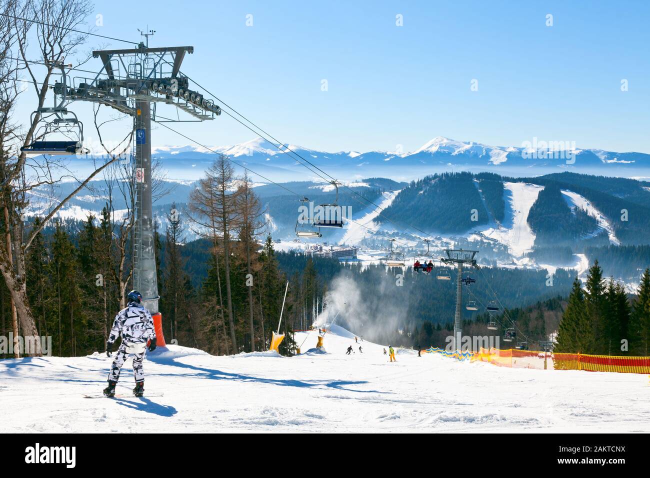 Snowborder going down the slope at ski resort Stock Photo