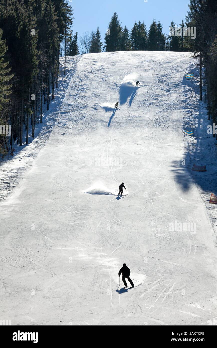 Skiers going down the slope at a ski resort Stock Photo