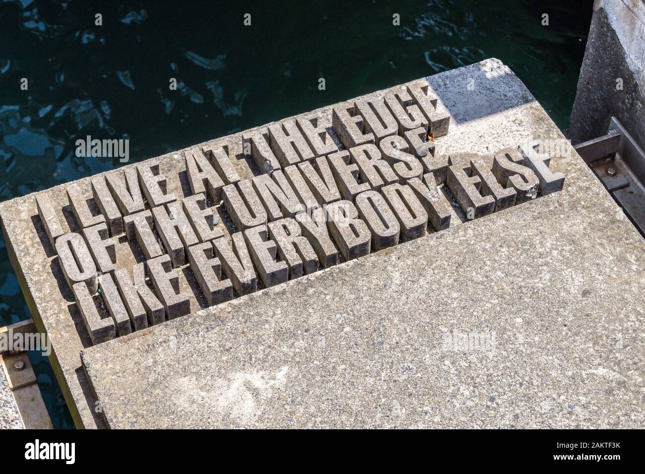'I live at the edge of the universe, like everybody else' quotation sculpture by Catherine Griffiths, Taranaki Street Wharf, Wellington, New Zealand Stock Photo