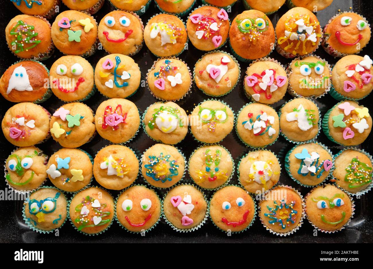 Close-up of a baking tray full of small homemade muffins with funny decoration ready for a children's birthday party Stock Photo