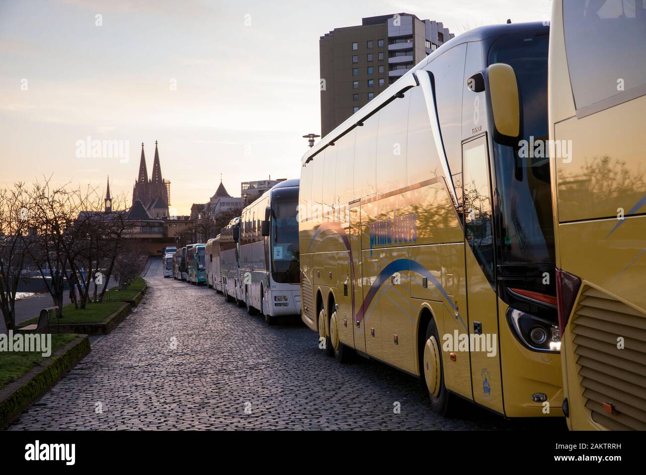 coaches park in long rows at the street Konrad-Adenauer-Ufer on the river Rhine, the cathedral, Cologne, Germany.  Reisebusse parken in langen Schlang Stock Photo