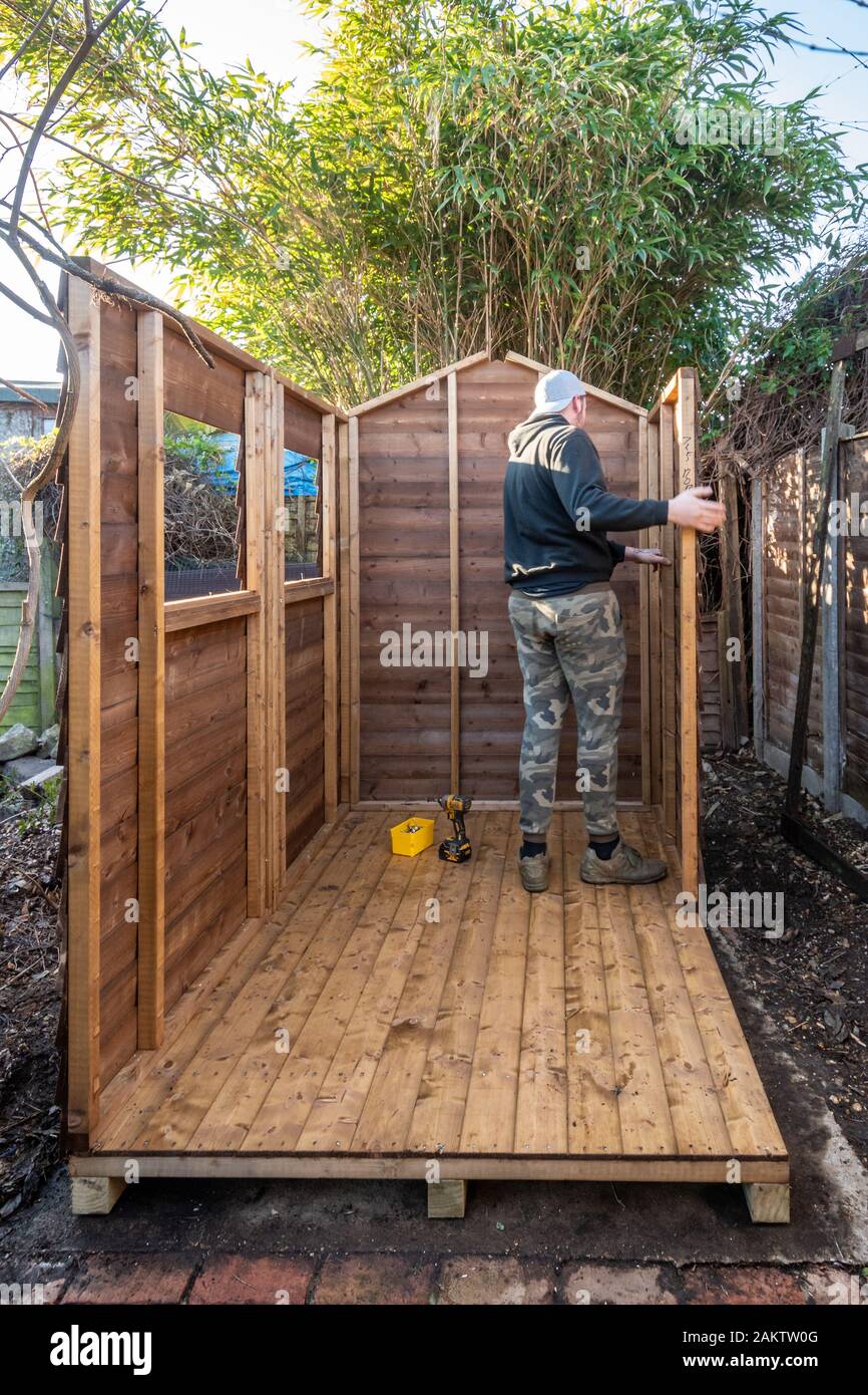 Man erecting a garden shed Stock Photo