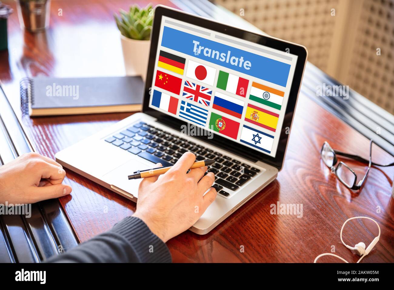 Online translation, foreign languages learning concept. Man working with a computer laptop, translate text on the screen. Stock Photo