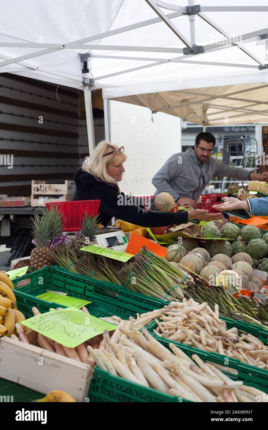 Stall holder selling seasonal fruit and veg at the market in Nay,Pyrenees Atlantiques, Nouvelle Aquitaine, France Stock Photo