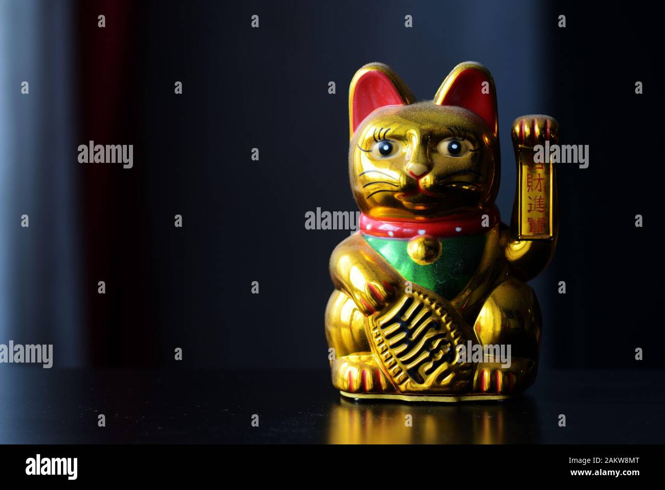 Golden Maneki Neko, the Lucky Cat, covered with dust. The concept of time and expectation of good luck Stock Photo