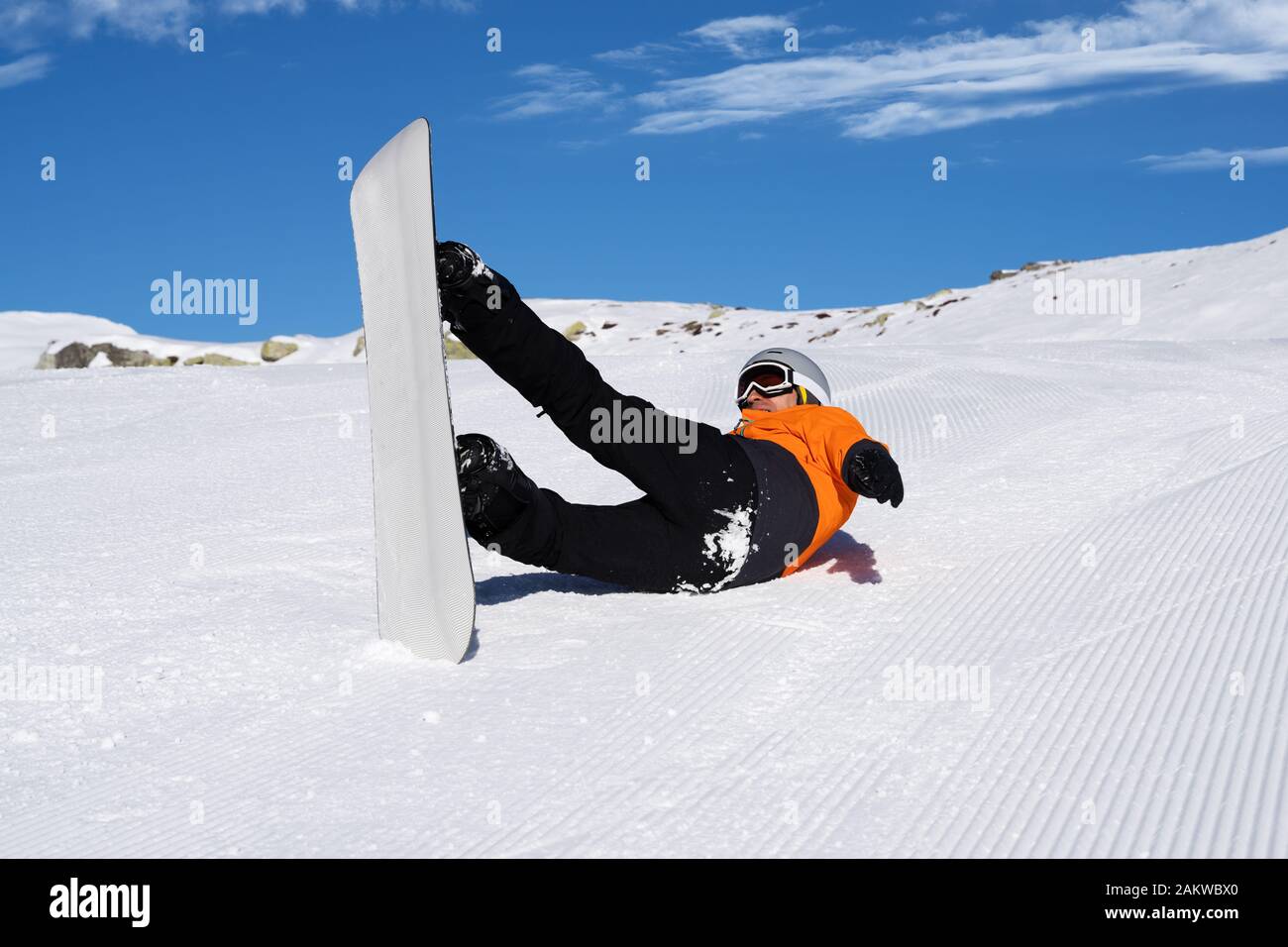 A Man In Orange Jacket Fall Down While Riding Snow Board On Snow Track Stock Photo