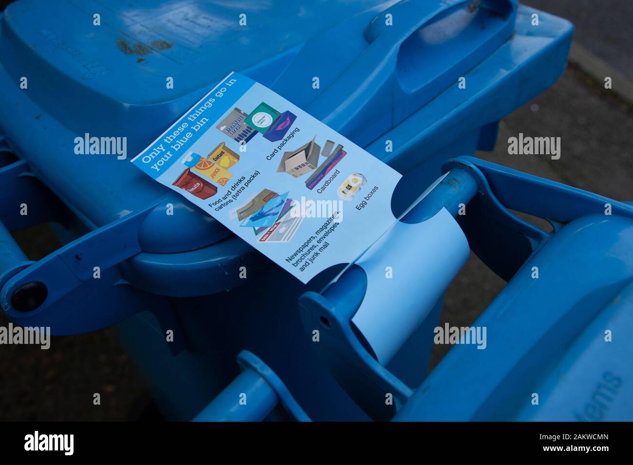 A warning tag attached to a blue recycling bin in Oldham, UK.  The resident had inclued things that could not be recycled in the paper recycling bin Stock Photo