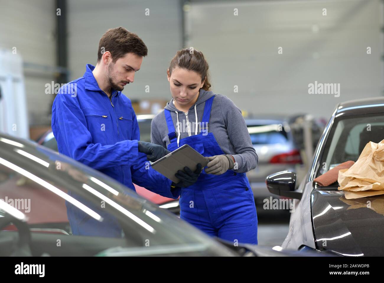 Apprentice in car industry using digital tablet Stock Photo
