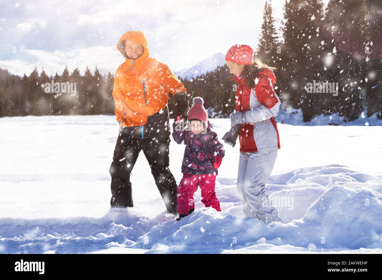 Happy Father And Mother With Their Daughter Playing In The Snow At Laax Stock Photo