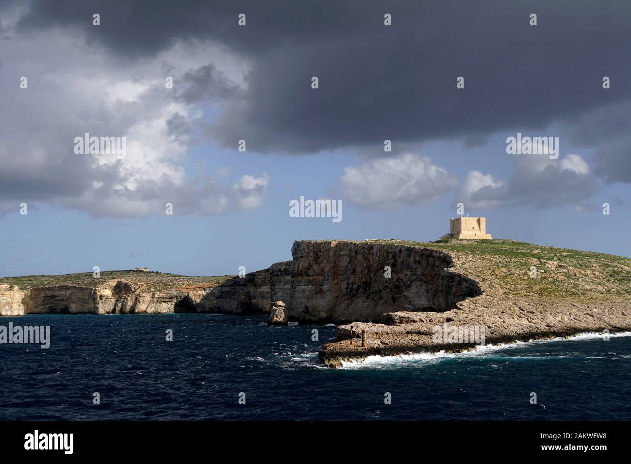 Regenwolken über Comino mit historischem Wachturm St. Mary's Tower, im Hintergrund Gozo, Malta Stock Photo