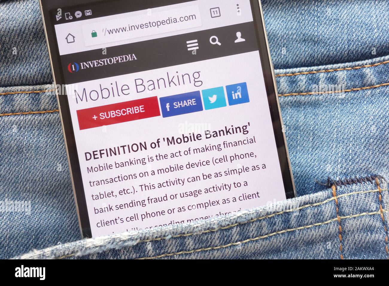 An article about mobile banking on Investopedia website displayed on  smartphone hidden in jeans pocket Stock Photo - Alamy