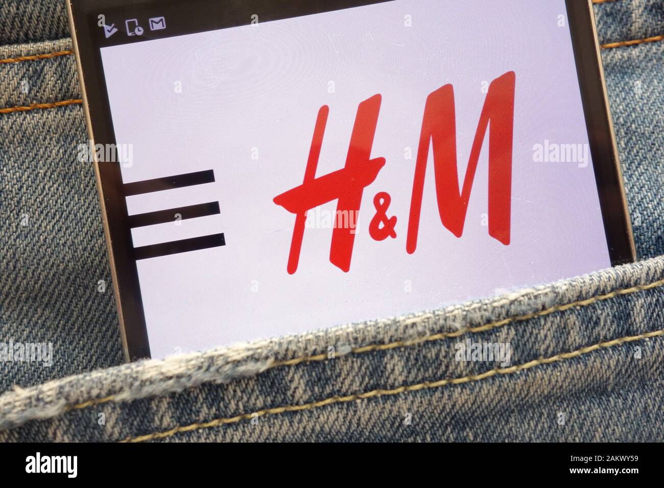 H&M website displayed on smartphone hidden in jeans pocket Stock Photo