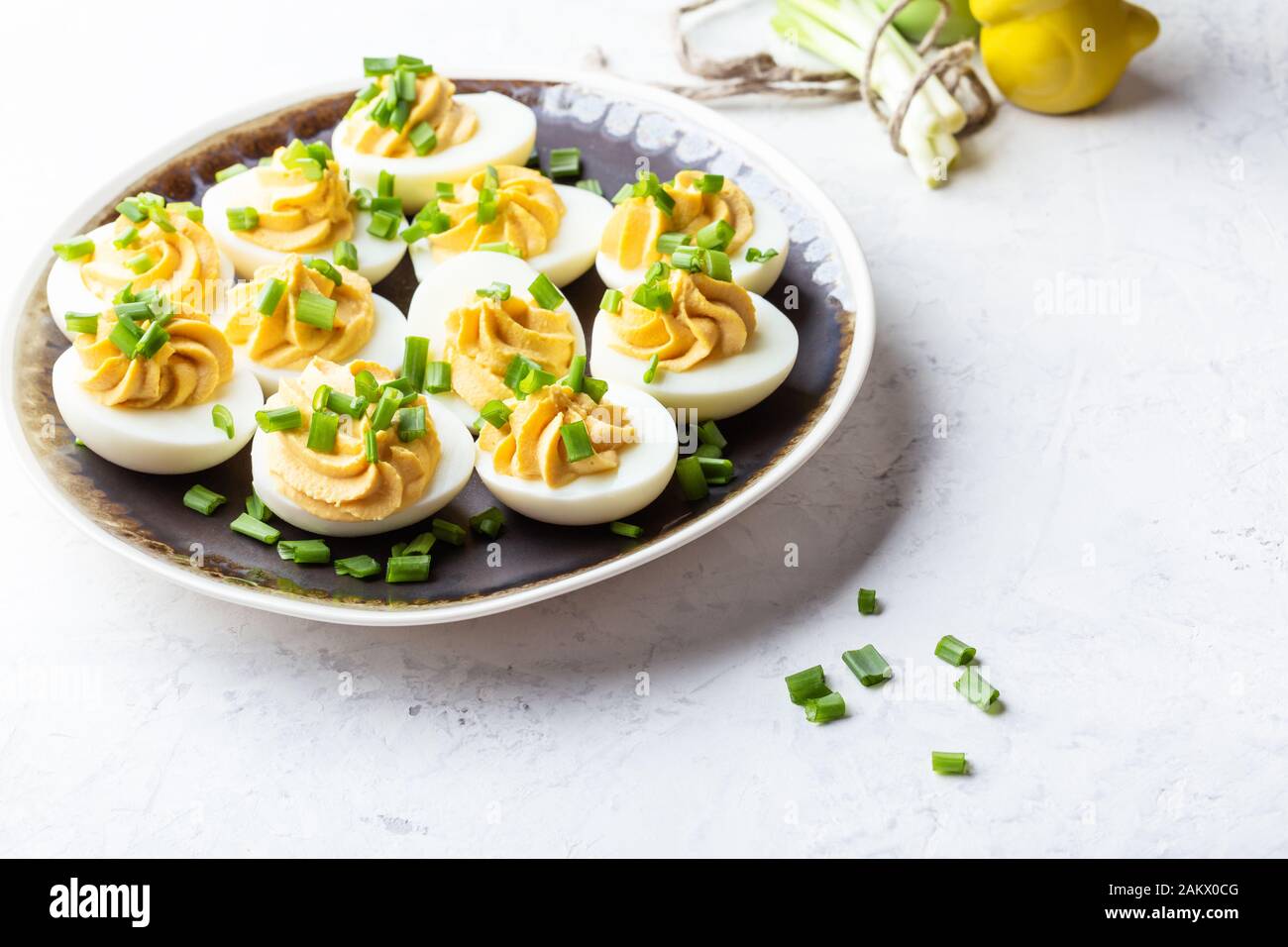 Deviled eggs in rustic ceramic plate, Easter party snack, close up Stock Photo