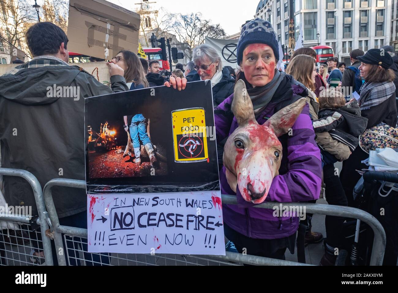 London, UK. 10th January 2020. A protester holds a kangaroo head and poster  at Extinction Rebellion protest at the Australian Embassy in solidarity  with protests in Sydney against the government over fires