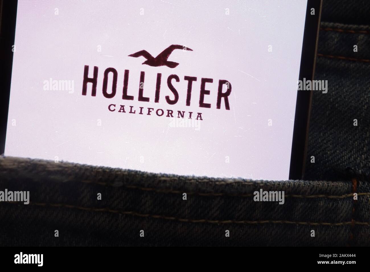 Hollister logo displayed on smartphone hidden in jeans pocket Stock Photo