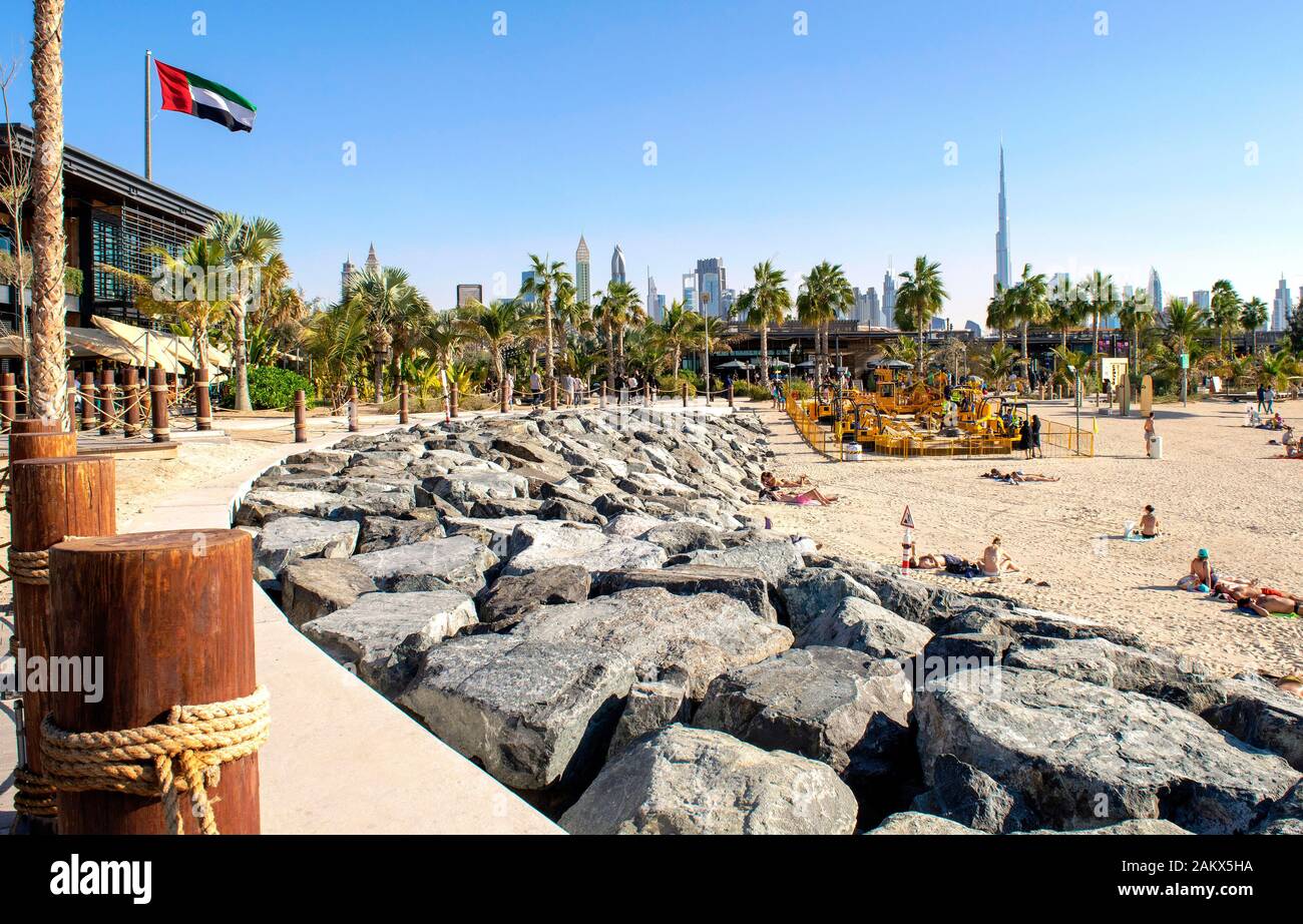 Dubai / UAE - December 20, 2019: La Mer Beach in Dubai. New modern public urban beach with beautiful city background. La Mer walk wuth UAE flag Stock Photo