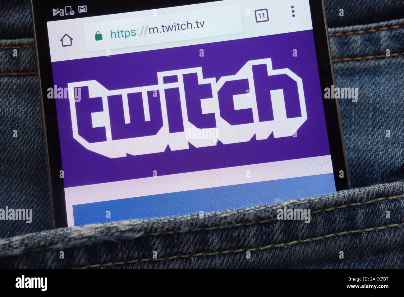 Twitch website displayed on smartphone hidden in jeans pocket Stock Photo