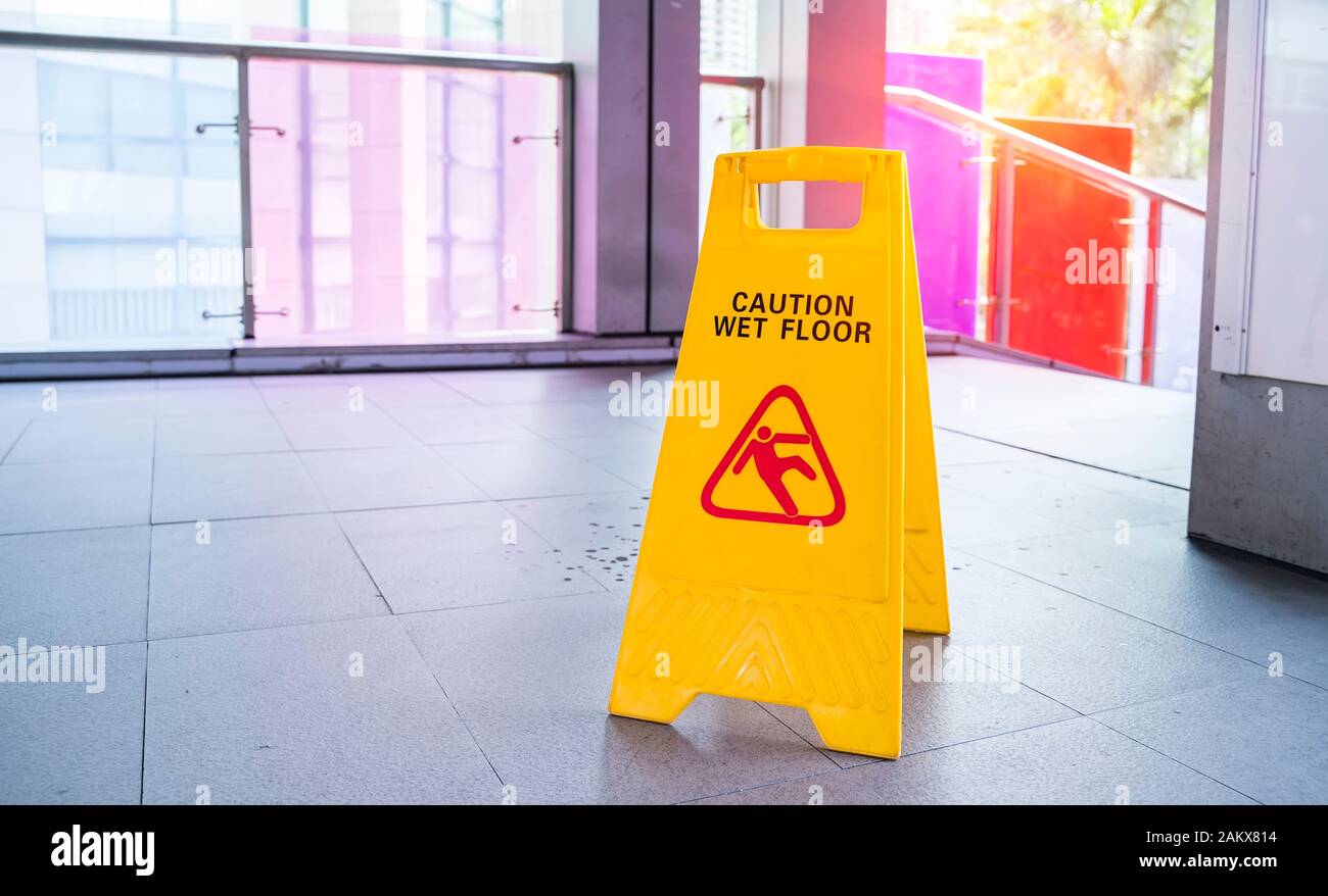 Yellow Caution wet floor sign on wet floor Stock Photo