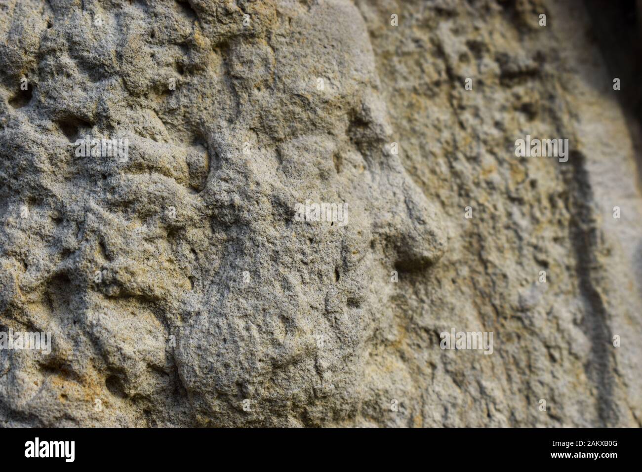 A close up view of a mans face in worn stone relief Stock Photo