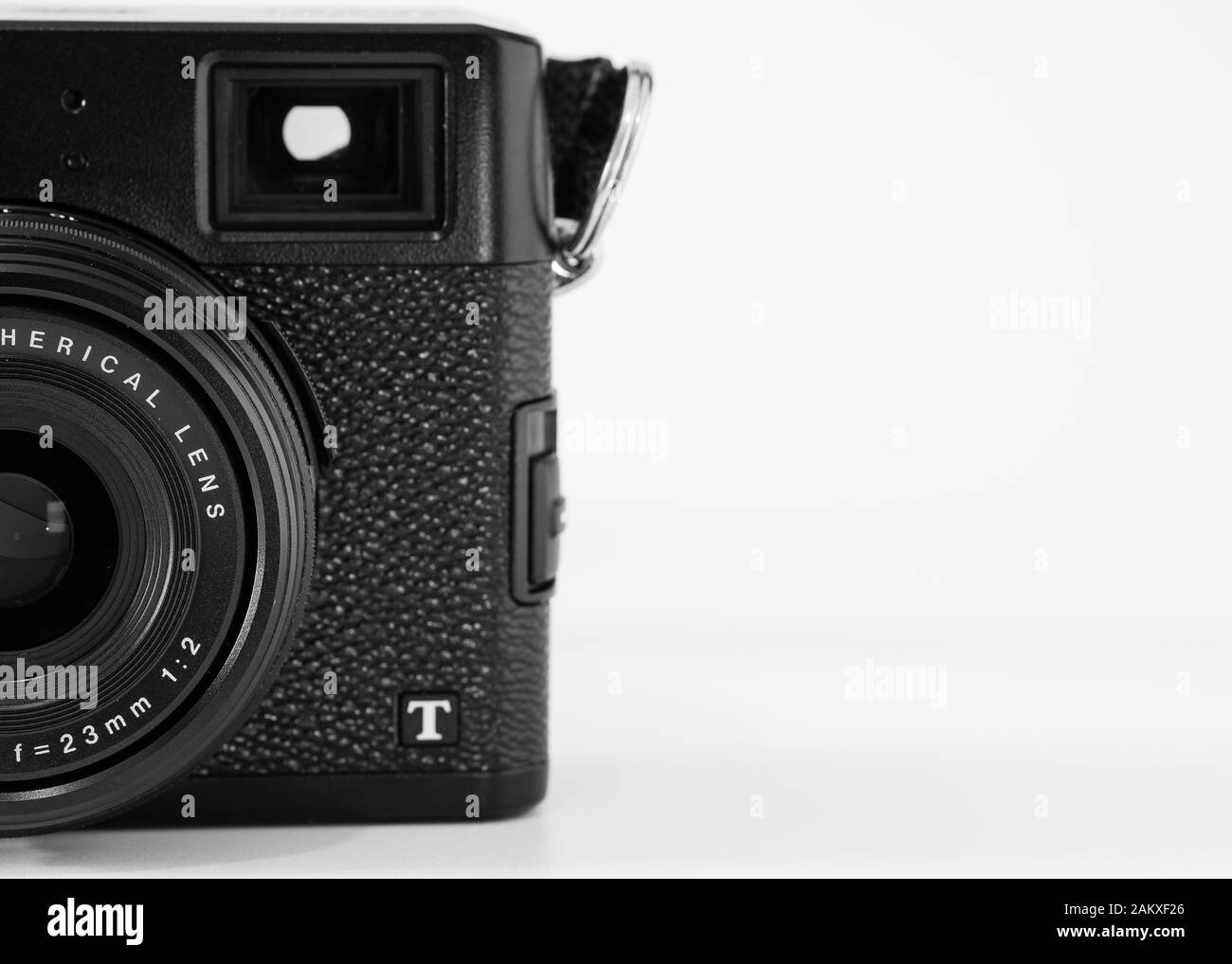 Partial view of a compact digital camera, Fujifilm brand, X100T model, optical viewfinder visible, monochrome image. Stock Photo