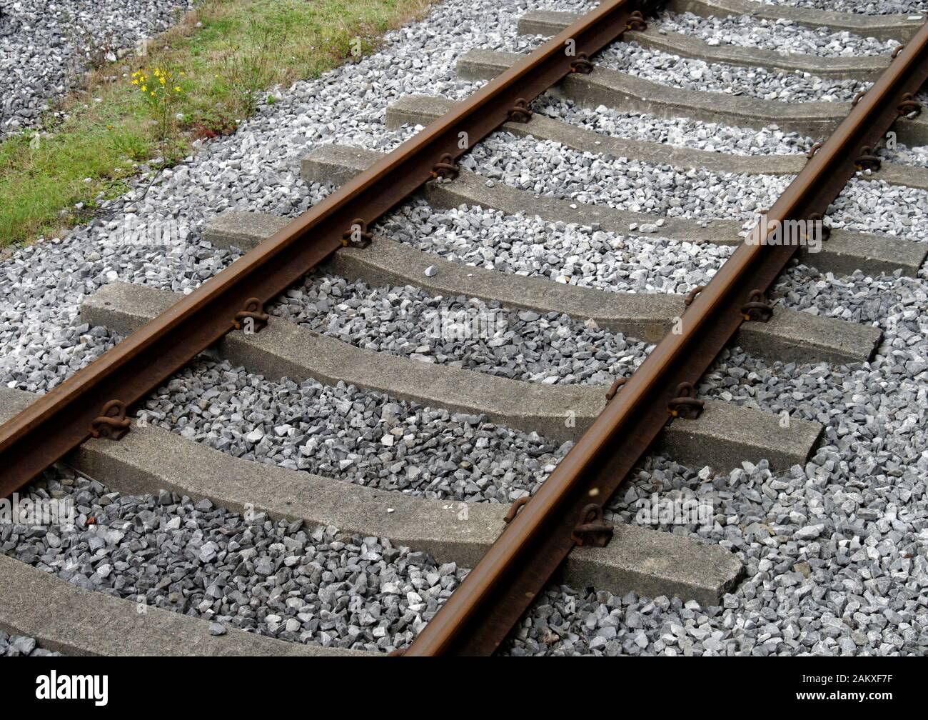 Railway permanent way using flat bottom rail clipped to concrete sleepers with Pandrol PR type clips. Stock Photo