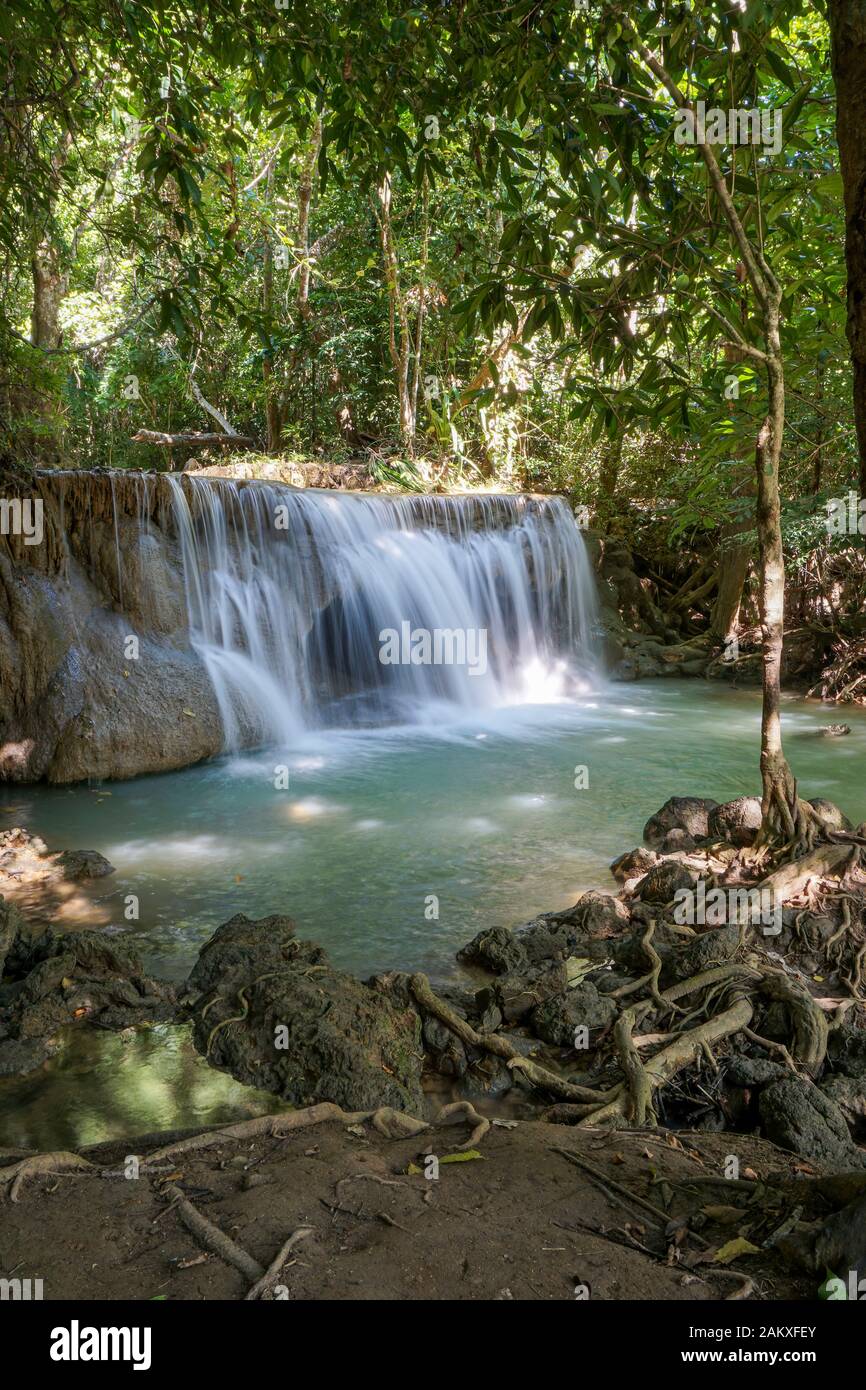 The clean waterfall there is an emerald green colour caused by reflections from trees and lichen circulating through the yellow limestone. Huai Mae Kh Stock Photo