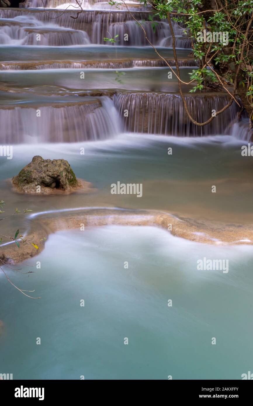 The clean waterfall there is an emerald green colour caused by reflections from trees and lichen circulating through the yellow limestone. Huai Mae Kh Stock Photo