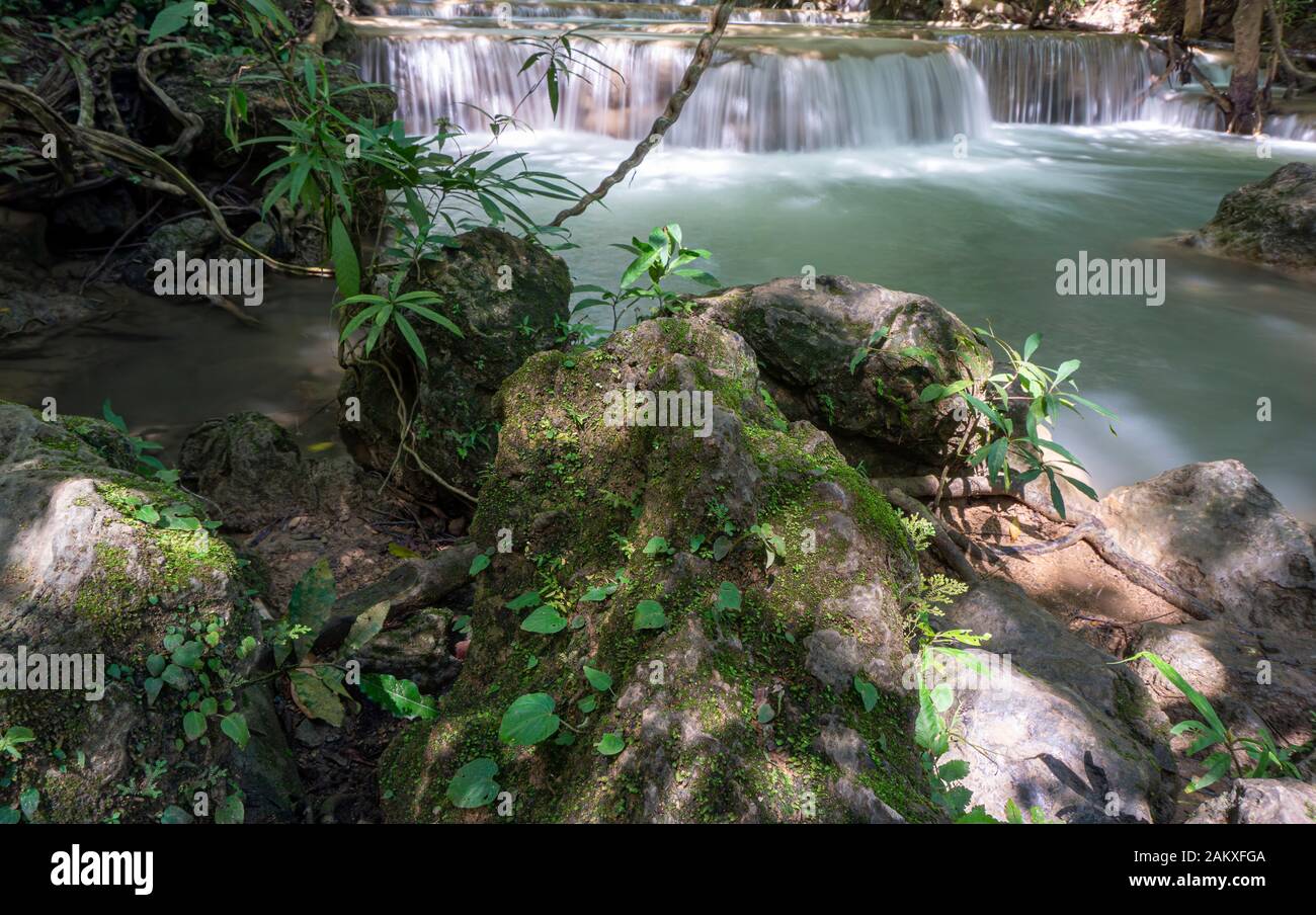 The clean waterfall there is an emerald green colour caused by reflections from trees and lichen circulating through the yellow limestone. Huai Mae Kh Stock Photo