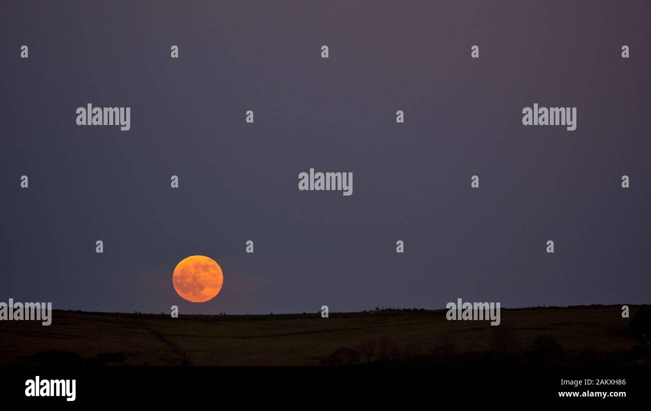 Weather UK First full Wolf Moon Penumbral Eclipse 10th January 2020 rising near Royston Rocks, Derbyshire Stock Photo