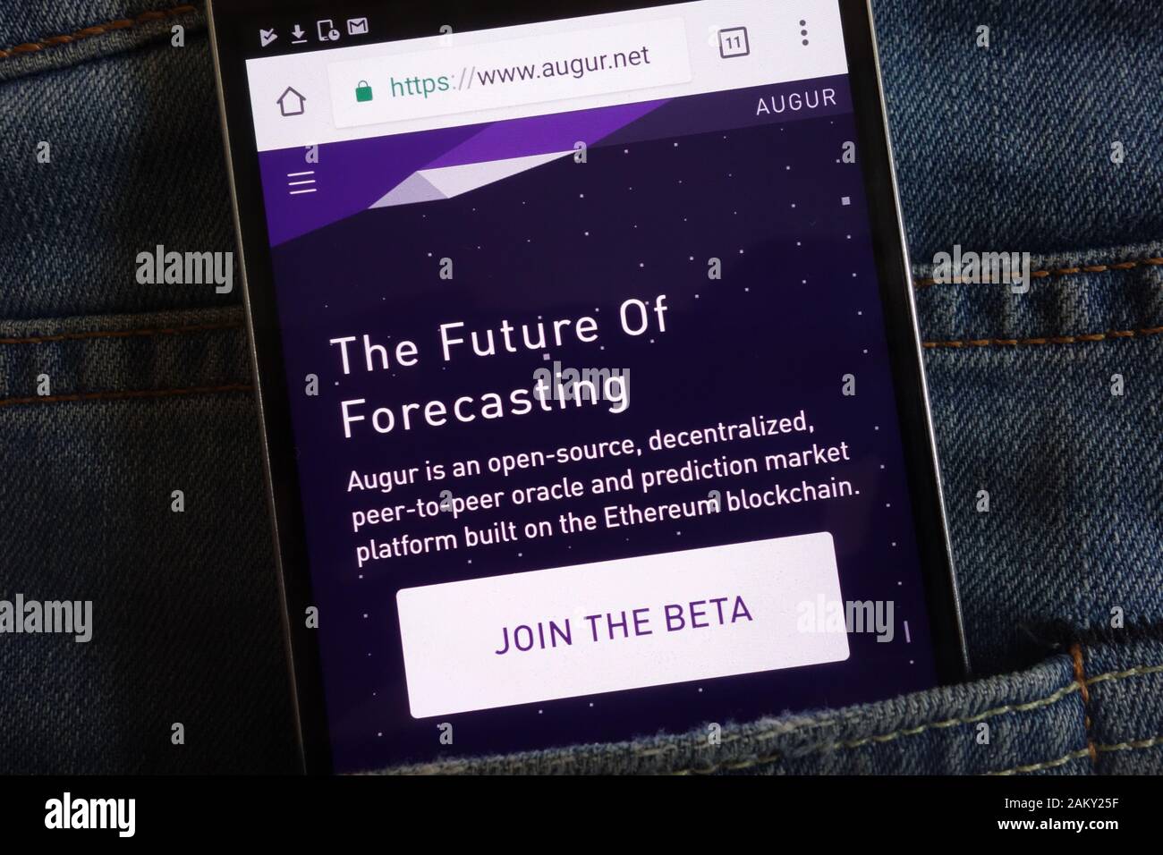 Augur cryptocurrency website displayed on smartphone hidden in jeans pocket Stock Photo