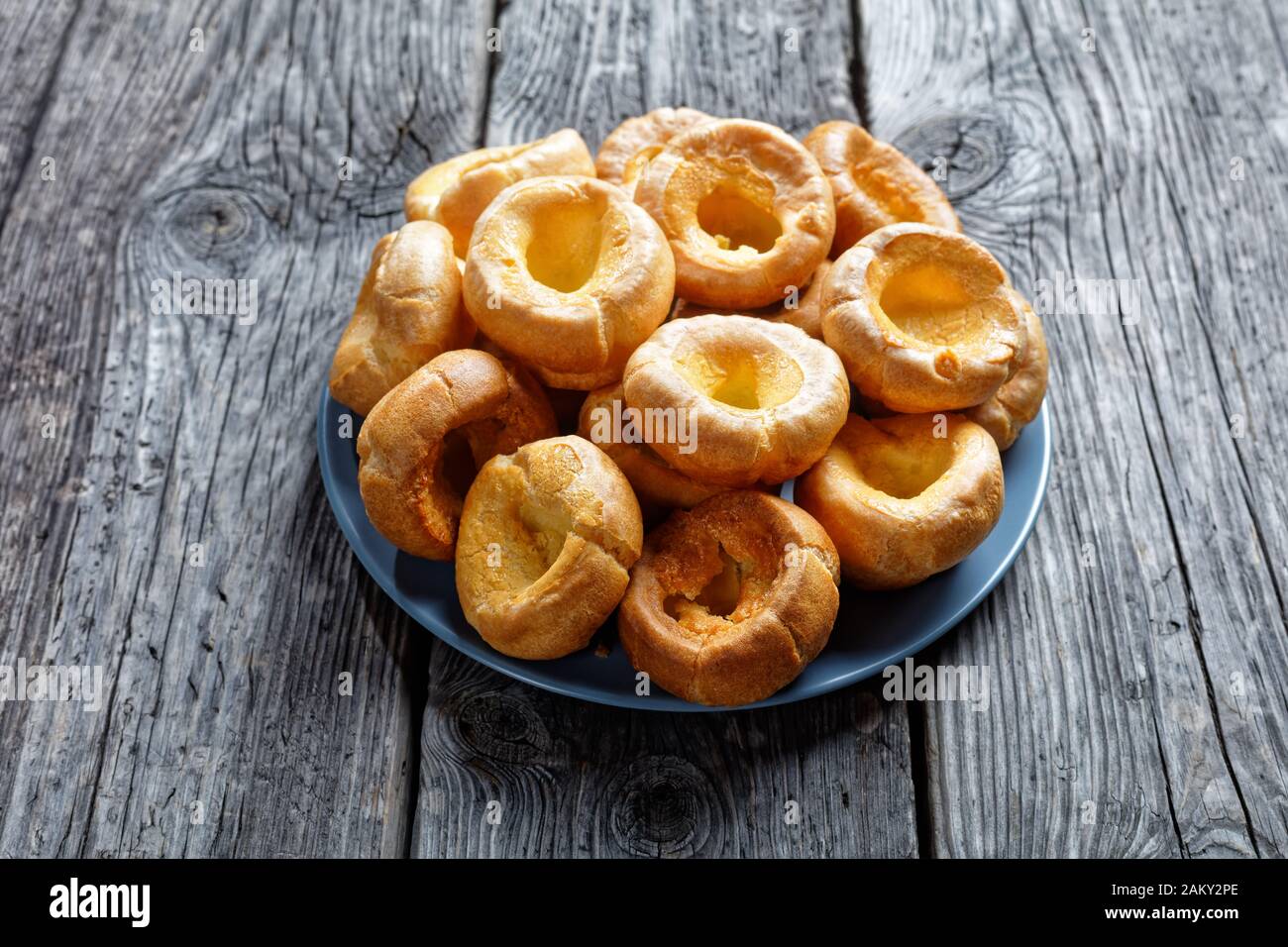 homemade Yorkshire puddings on a platter on a rustic wooden table, english cuisine, view from above Stock Photo
