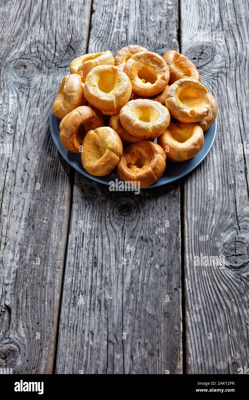 Yorkshire puddings on a platter on a rustic wooden table, english cuisine, view from above Stock Photo