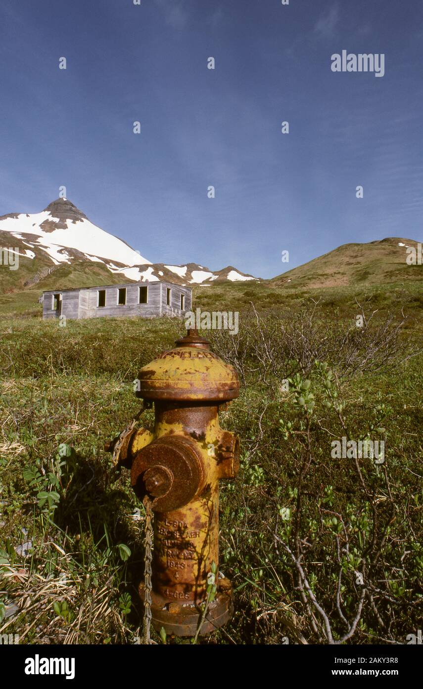 Fire hydrant and abandoned military barracks from WWII, housed troops to gend off Japanese invasion. Dutch Harbor, Aleutian Islands Alaska. Stock Photo