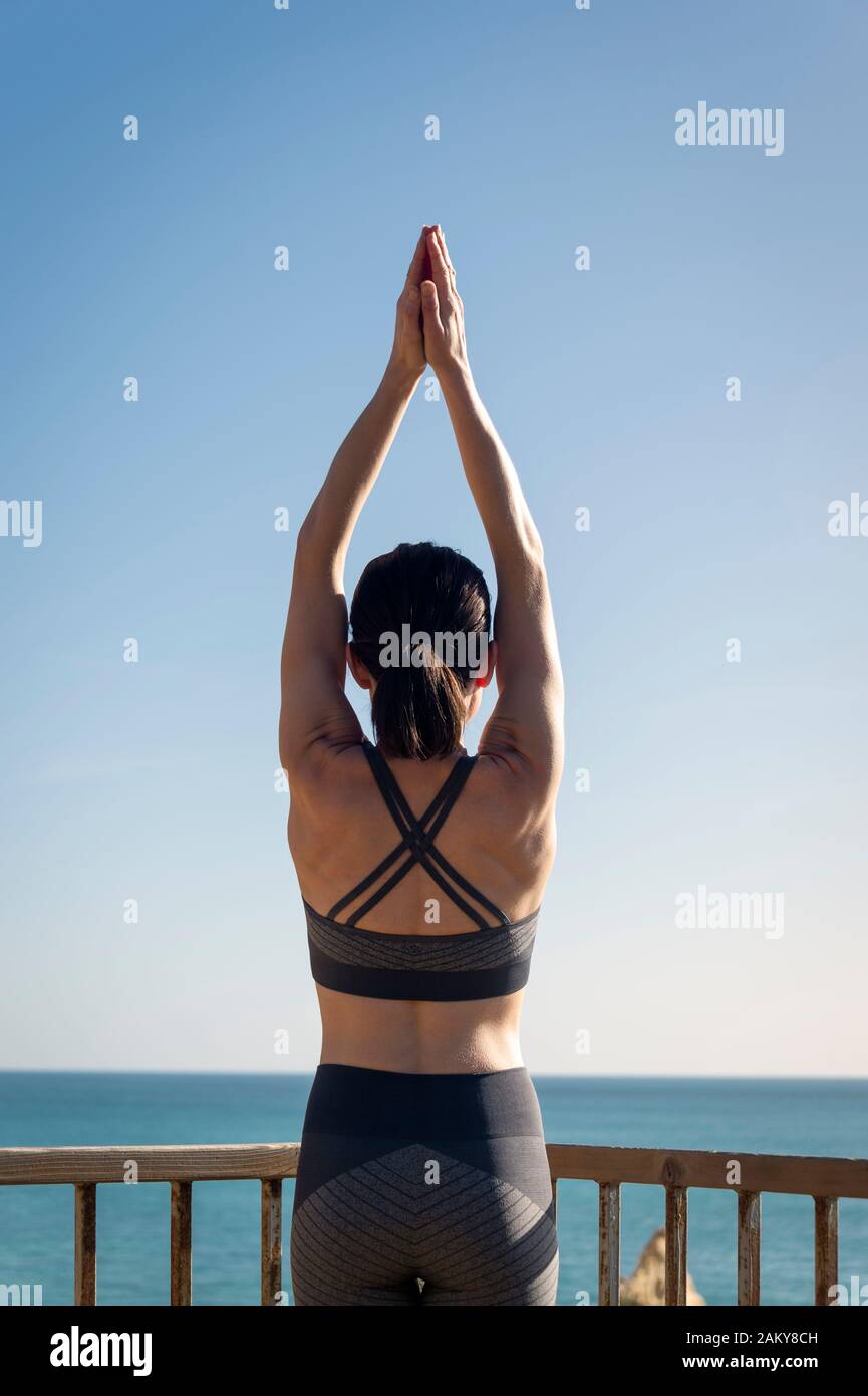 woman doing yoga moutain pose, back view. Stock Photo