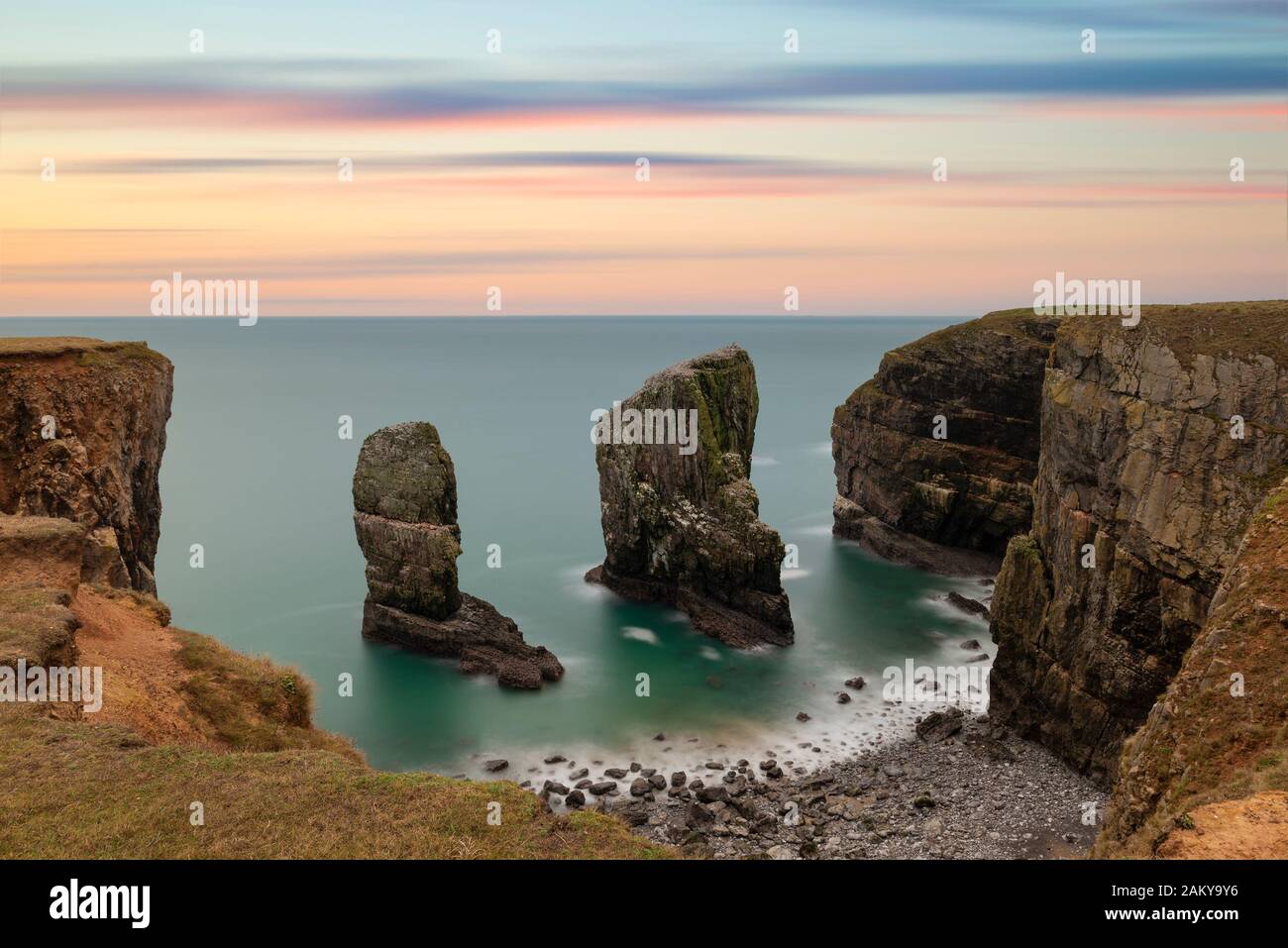 Epic landscape image of Elegug Stacks in Wales long exposure during stunning colorful sunset Stock Photo