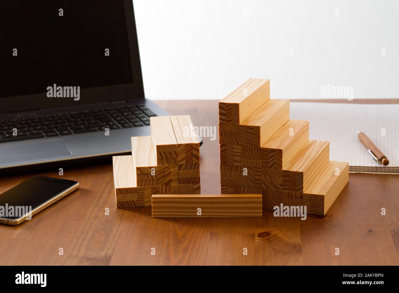 wooden building bricks arranged to symbolize gender gap, discrimination, unequal pay, inequality, or similar business/social Topics with one brick lef Stock Photo