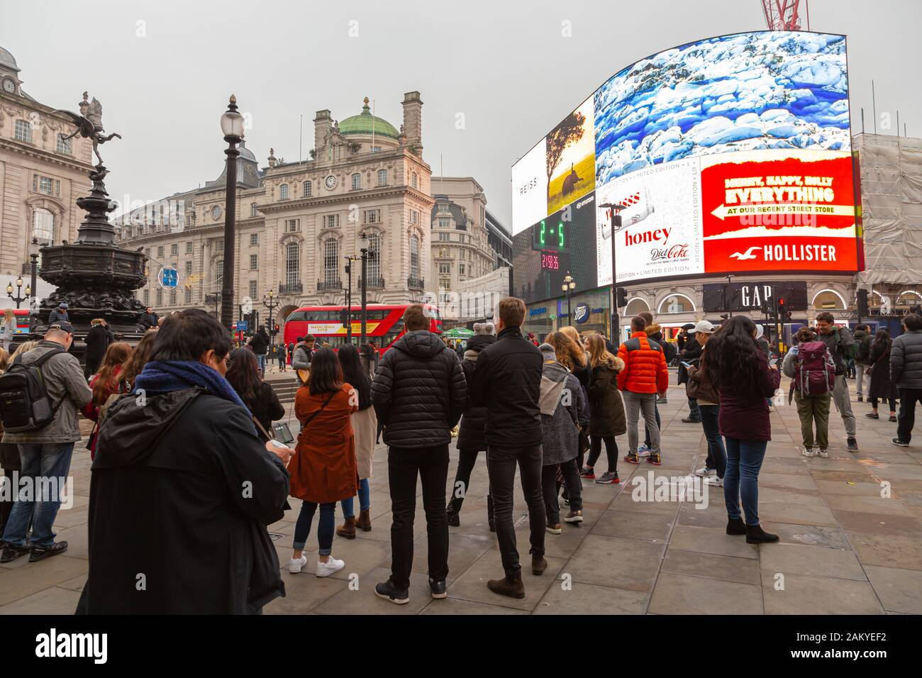 LONDON, UK - December 31, 2019: Some people listen to a busker in Piccadilly Circus Stock Photo