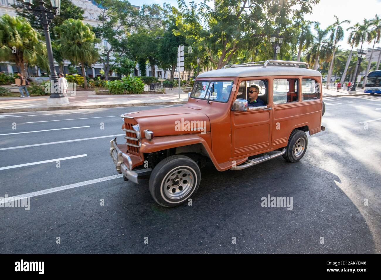 A classic brown Willys Jeep staton wagon driving down the street in Havana, Cuba Stock Photo