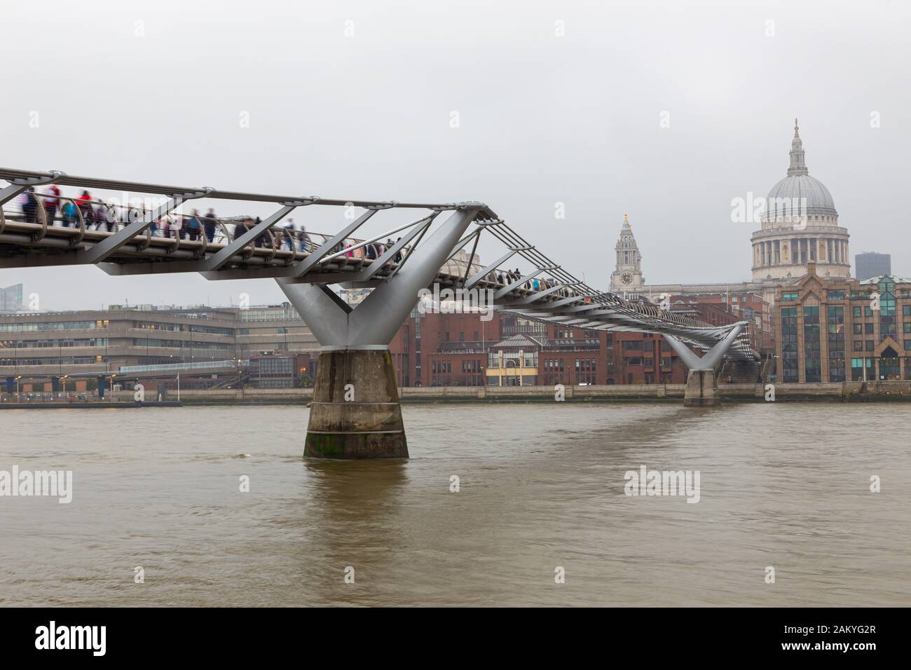 Urban view of London with Millennium bridge, St. Paul Cathedral and Thames river in a cloudy day. Stock Photo