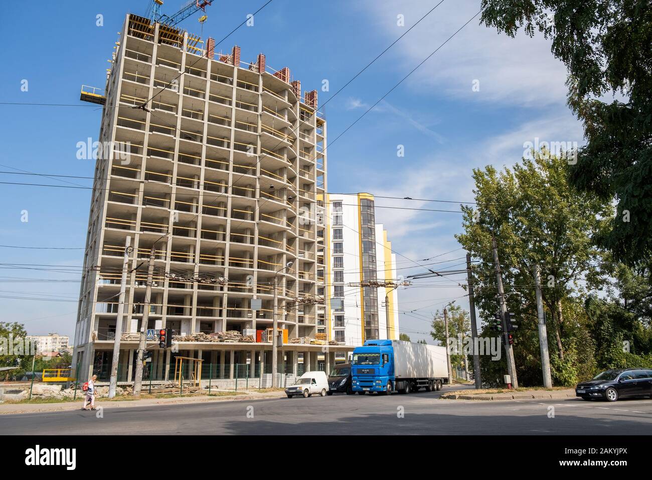 Concrete frame of tall apartment building under construction and tower ...