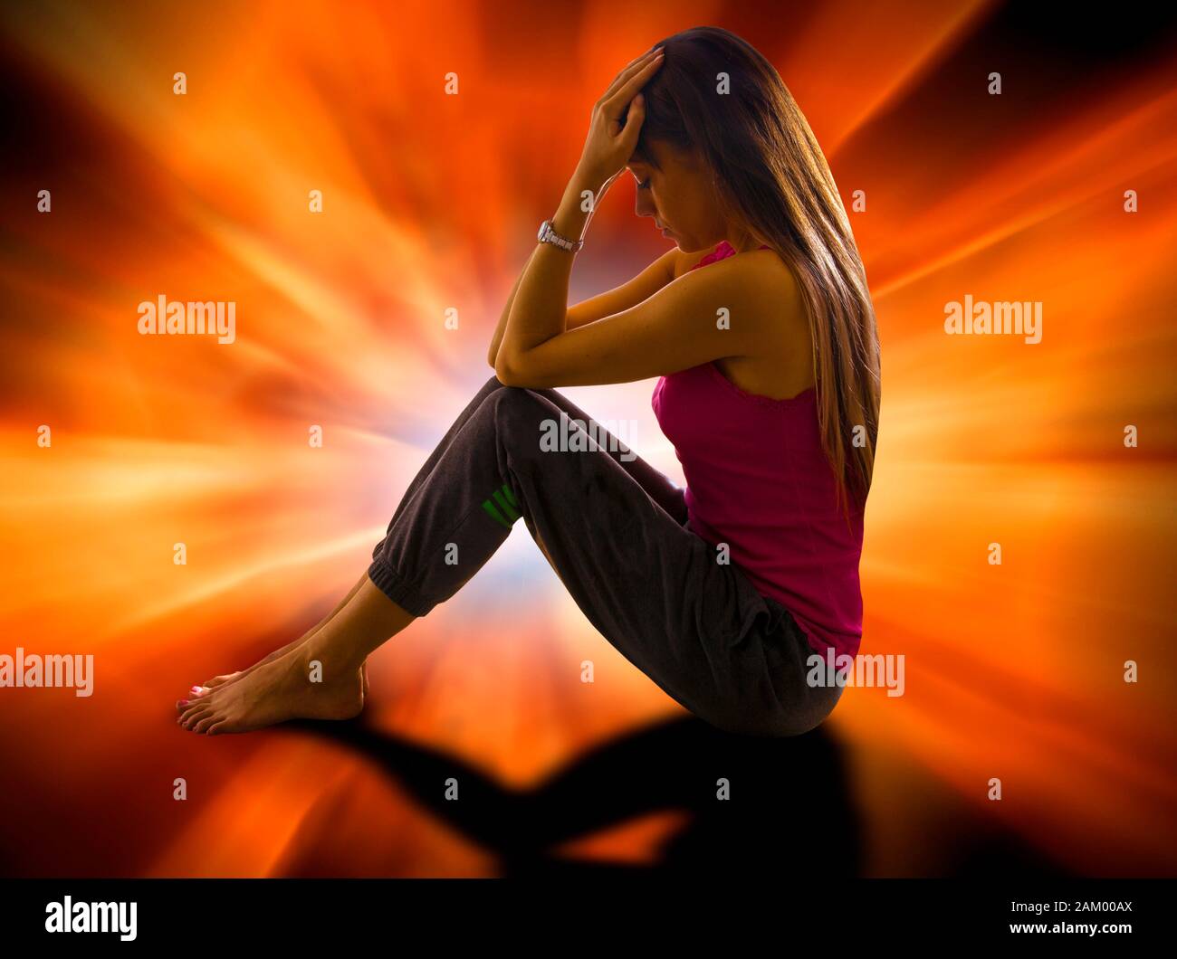 Woman sitting with head in hands Stock Photo