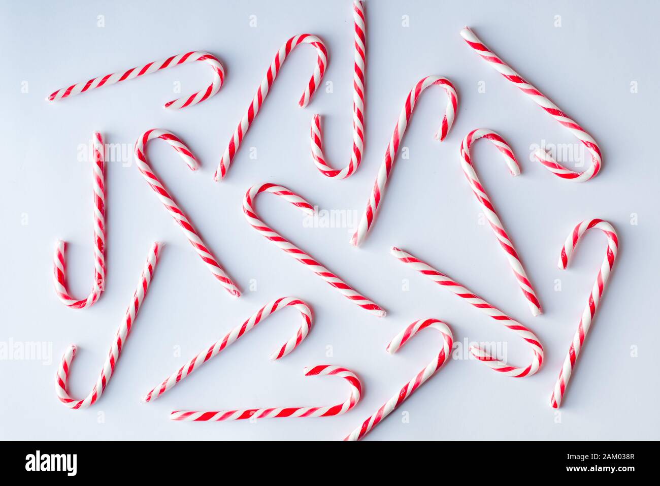 Overhead image of candy canes scattered on a plain white background. Stock Photo