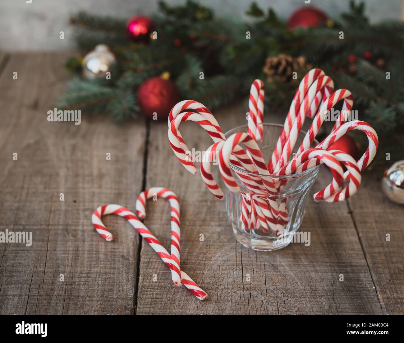 High angle shot of a glass of candy canes against Christmas backdrop. Stock Photo