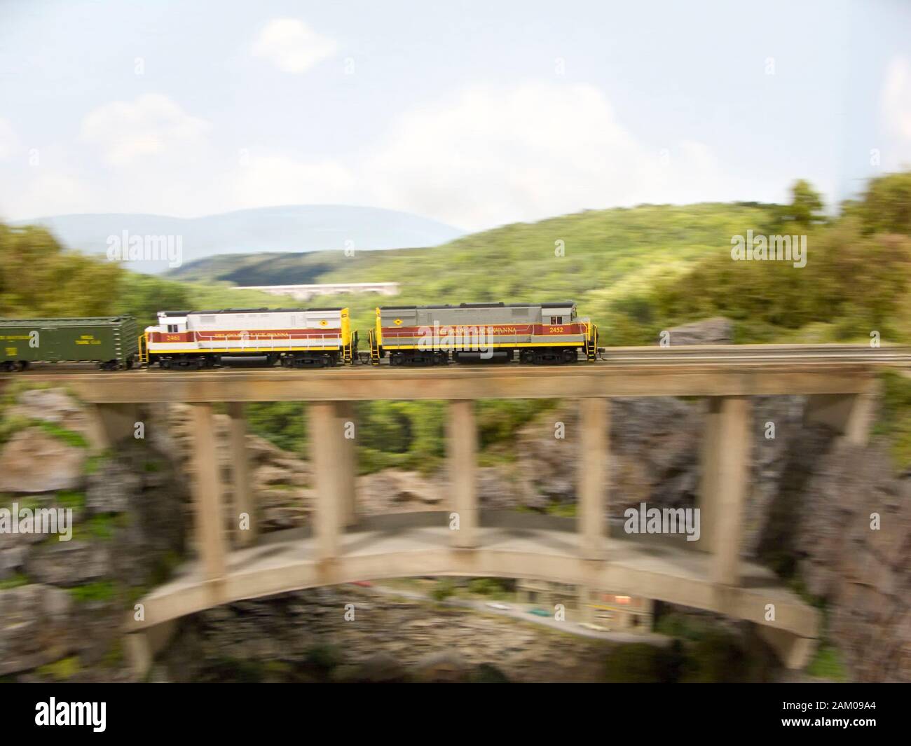 HO gauge diesel engines pulling a freight train cross and expertly