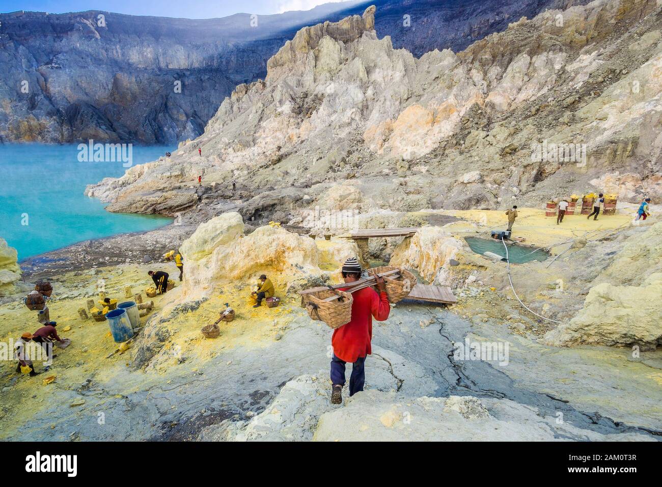 Sulphur miner hiking down into the crater of Kawah Ijen volcano in East Java, Indonesia. Stock Photo