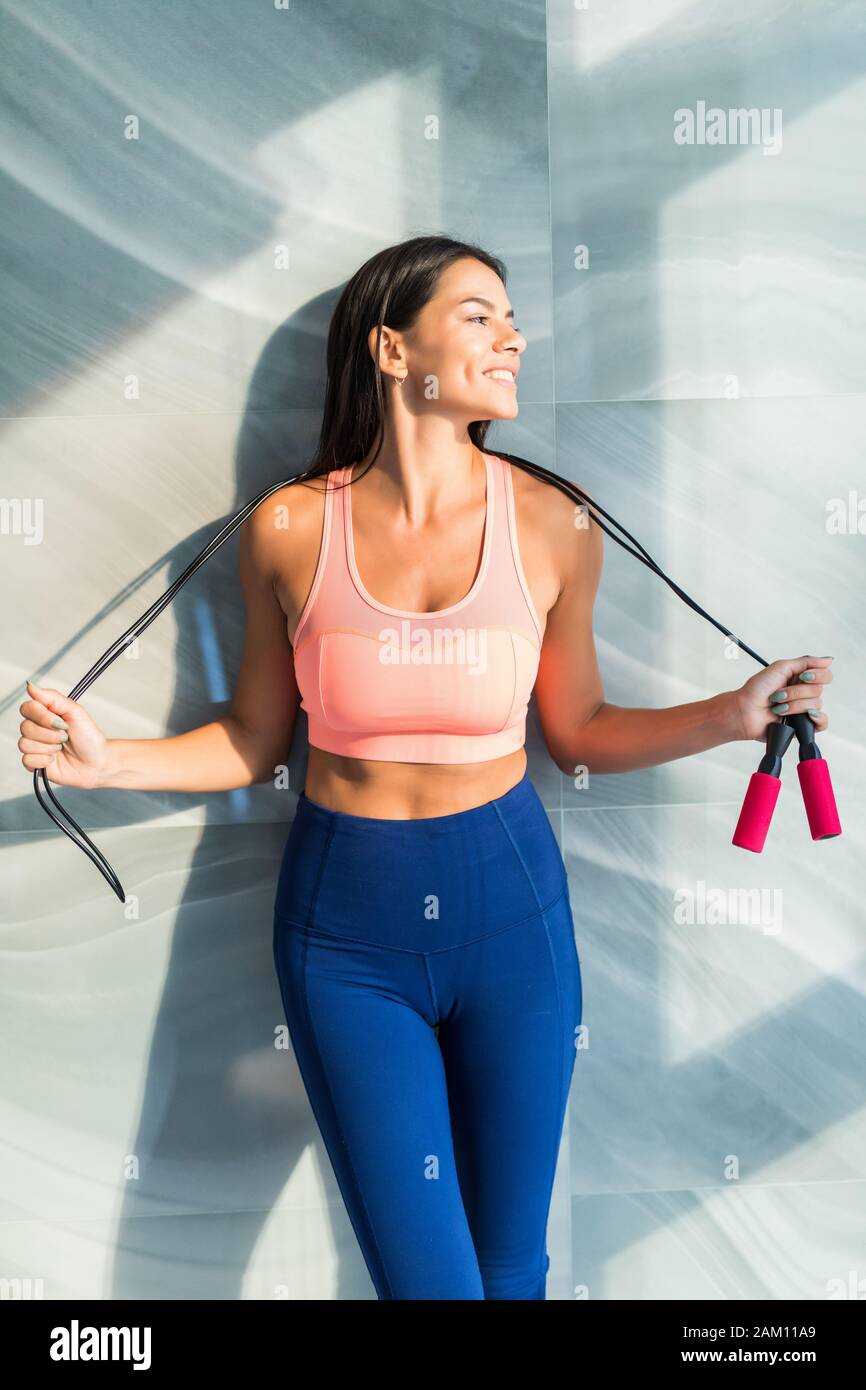 healthy sports woman in fitness clothes with a jump rope and heart rate ...