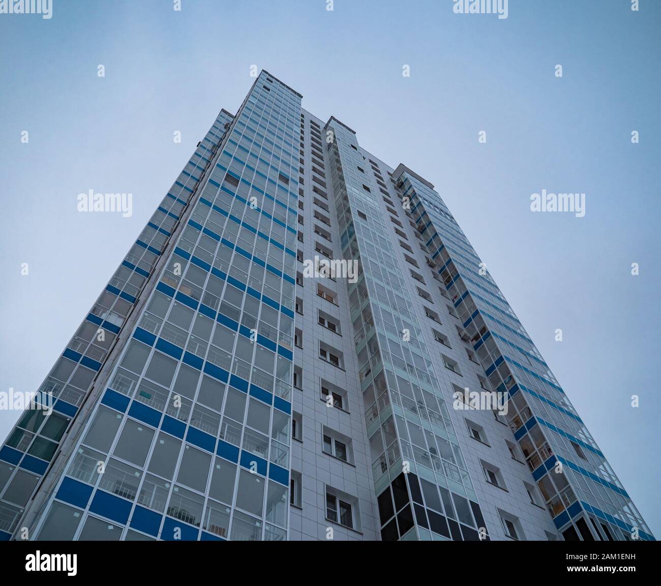 New highrise residential tower on blue sky background Stock Photo - Alamy