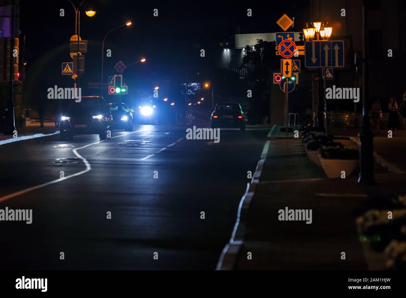view of city night road with cars standing on crossroad. car lights shining bright Stock Photo