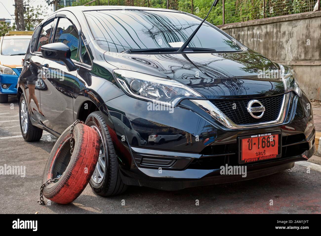 Vehicle clamped for illegal parking by private contractor using a car tyre. Thailand Southeast Asia Stock Photo